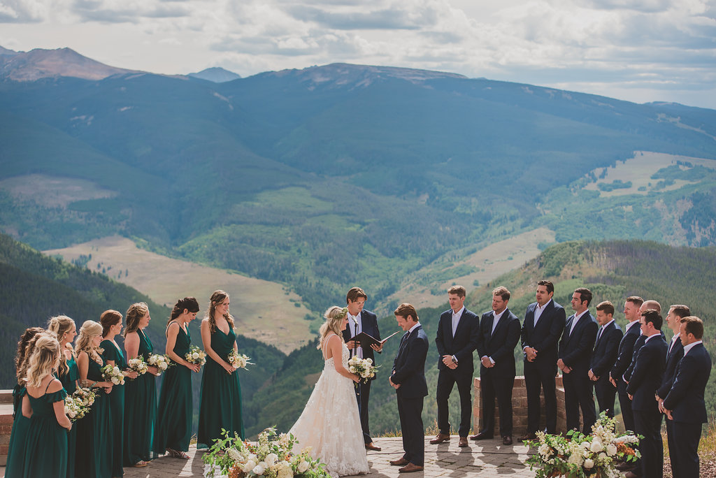Wedding party standing on Colorado mountain outlook.