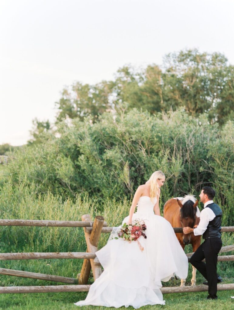 Bride and groom pose with horse at Brush Creek Ranch