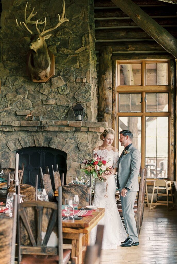Newlyweds pose in Trailhead Great Room at Brush Creek Ranch